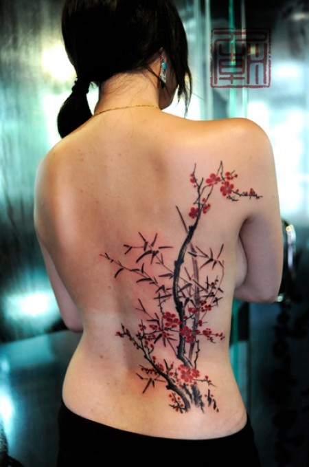 Tatuaje de unas plantas de bambú en la espalda de una mujer