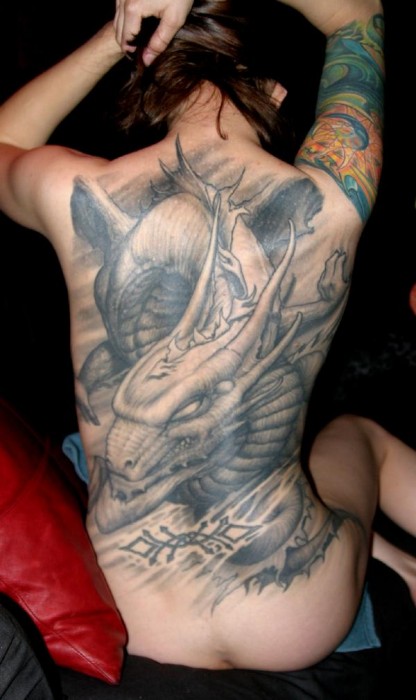 Tatuaje de un gran dragon en la espalda de una mujer
