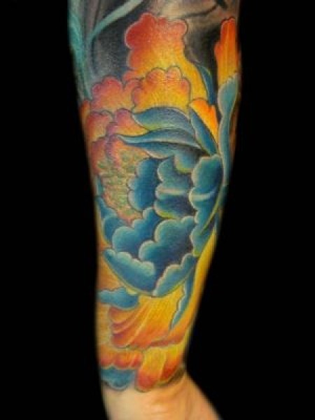 Tatuaje de una gran flor de loto en el antebrazo
