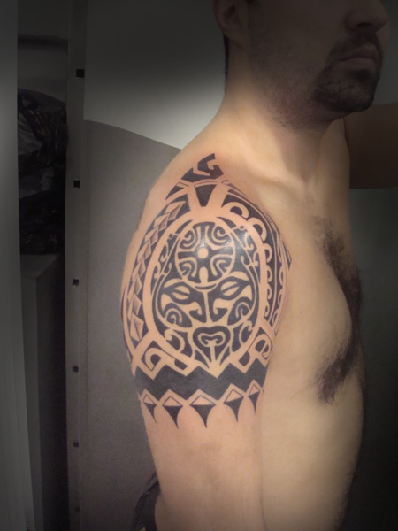 Tatuaje de una mascara maorí en el hombro