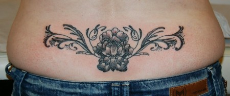 Tatuaje de una flor en la zona lumbar