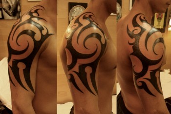 Tatuaje de un tribal en hombro y brazo