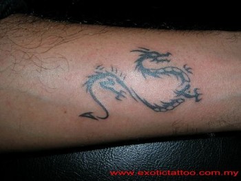 Tatuaje de una pequeña sombra de dragón en el antebrazo