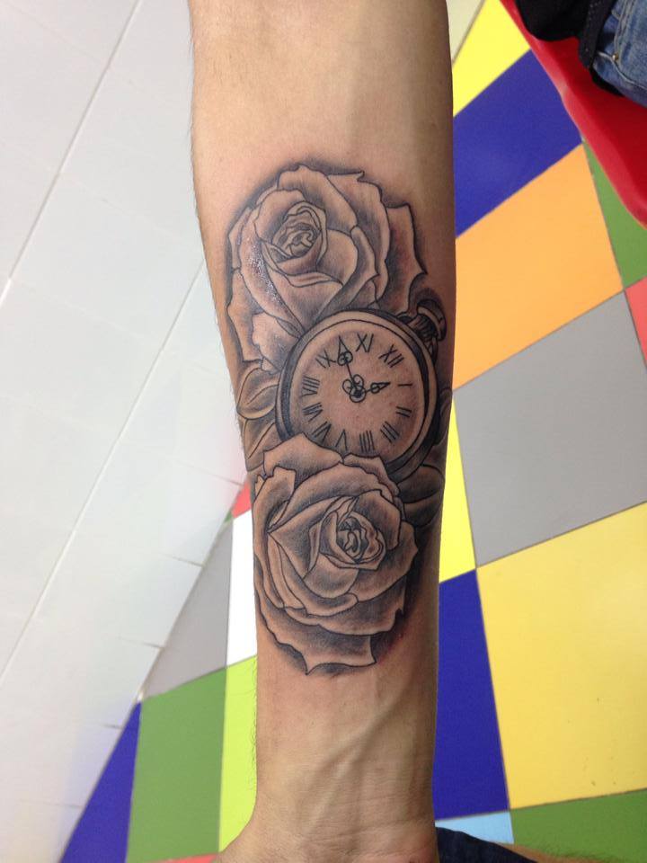 Tatuaje de un reloj de pulsera entre un par de rosas
