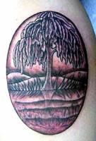 Tatuaje de un árbol reflejándose en un lago