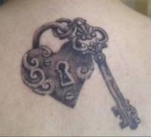 Tatuaje de un cerrojo corazón con su llave al lado