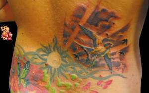 Tatuaje de un sol, y un paisaje de golondrinas 