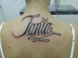 Tatuaje del nombre Tania en la espalda