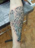 Tatuaje de un brazo con engranajes y un escorpión