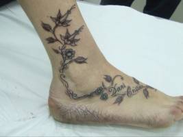 Tatuaje de unas plantas por el pie de una chica