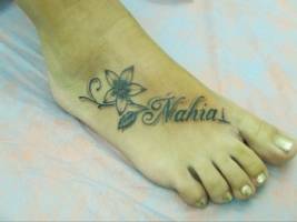 Tatuaje de un nombre en el pie con una flor