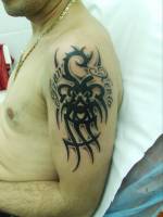 Tatuaje de un tribal rodeado con dos nombres