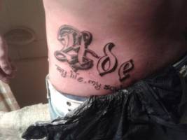Tatuaje de un nombre en el costado