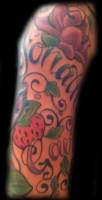 Tatuaje de un nombre con unas flores y fresas