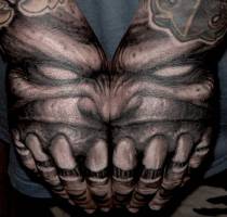 Tatuaje de la cara de un monstruo formada con ambas manos