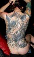 Tatuaje de un gran dragon en la espalda de una mujer