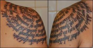 Tatuaje de un texto escrito en espiral en el hombro