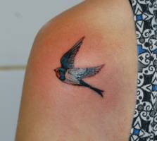 Tatuaje de un pequeño pájaro en el hombro
