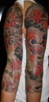 Tatuaje de nubes y flores de estilo japonés en el brazo