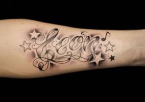 Tatuaje del nombre Leon entre notas y estrellas