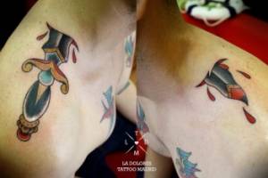 Tatuaje de una daga atravesando el hombro