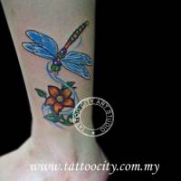 Tattoo de una libélula volando hacia una flor
