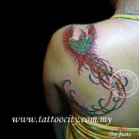 Tatuaje de un ave fénix volando por la espalda de una chica