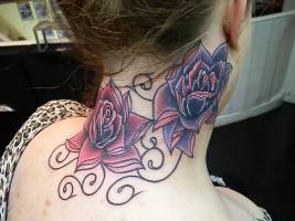 Tatuaje de grandes flores a color en el cuello de una mujer