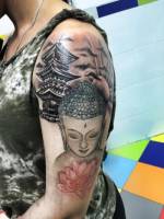 Tatuaje de un buda junto a una pagoda y un sol
