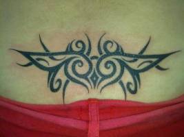 Tatuaje de un tribal en la rabadilla