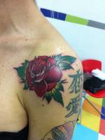 Rosa a color tatuada en el hombro