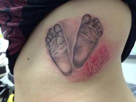 Tatuaje de unos pies de bebé en el costado
