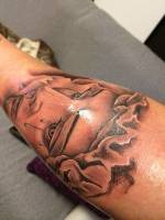 Virgen llorando tatuada en el brazo