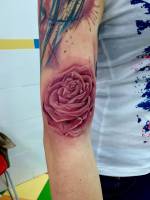 Tatuaje de una rosa a color en el antebrazo